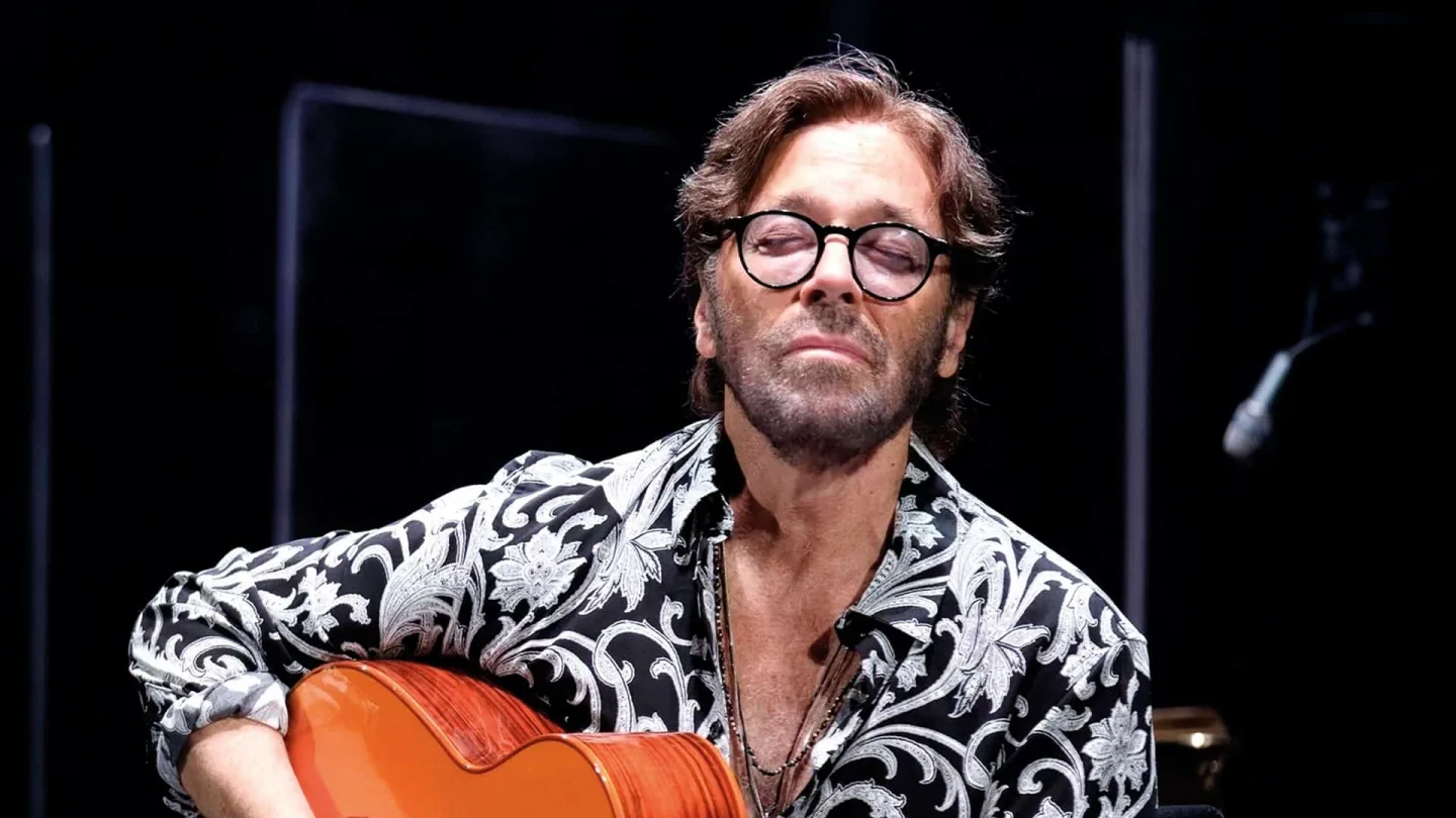 Al Di Meola holding his guitar in the official Misty Fest programme photograph