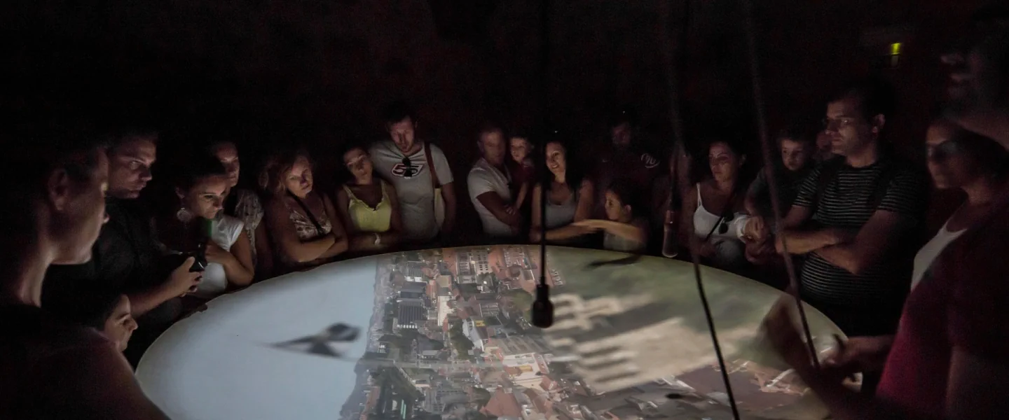 Visitors watching the live Lisbon projection around the castle camera-obscura table