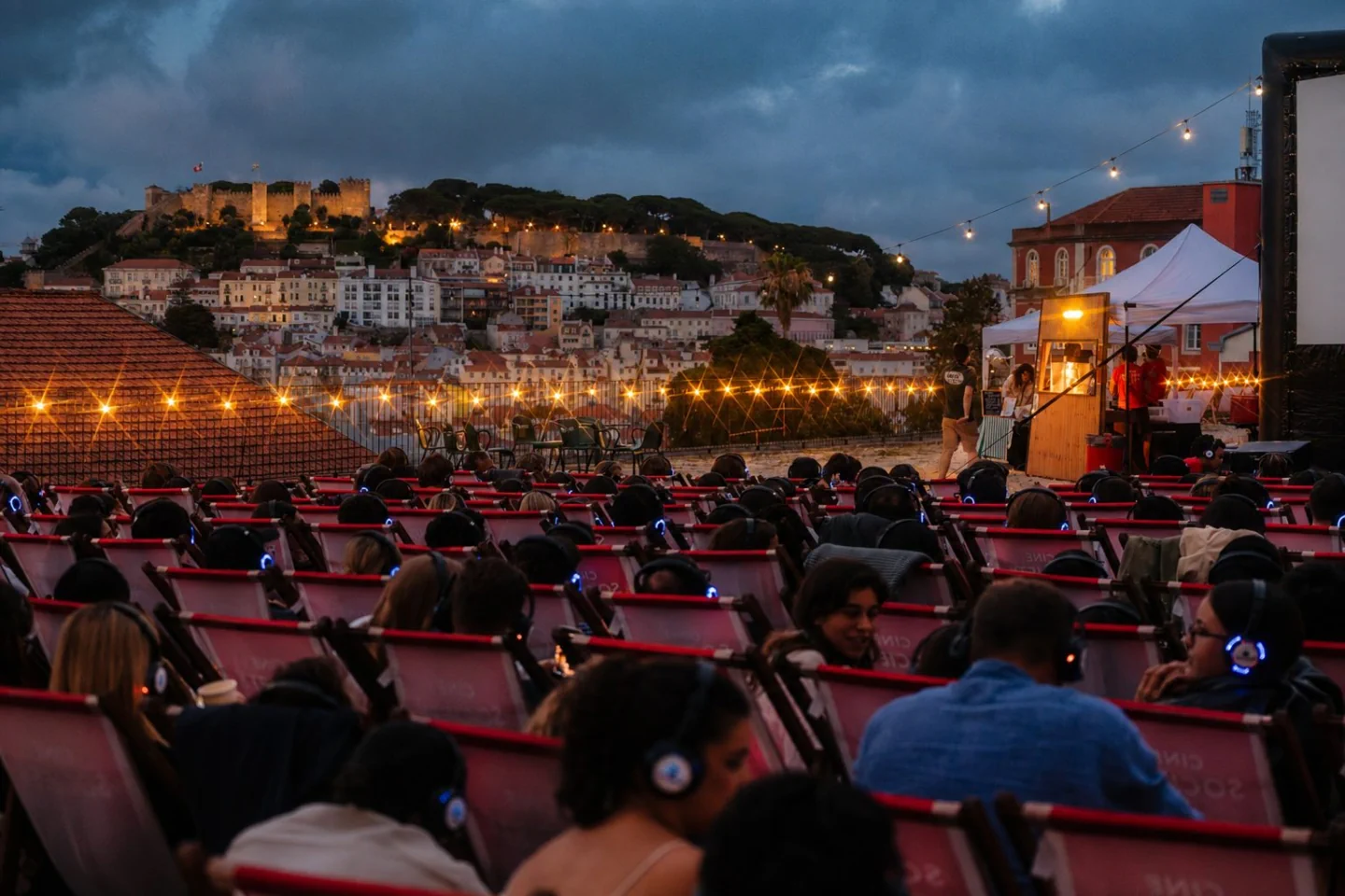 CineSociety audience in deck chairs at Príncipe Real Terrace with Lisbon’s castle across the rooftops