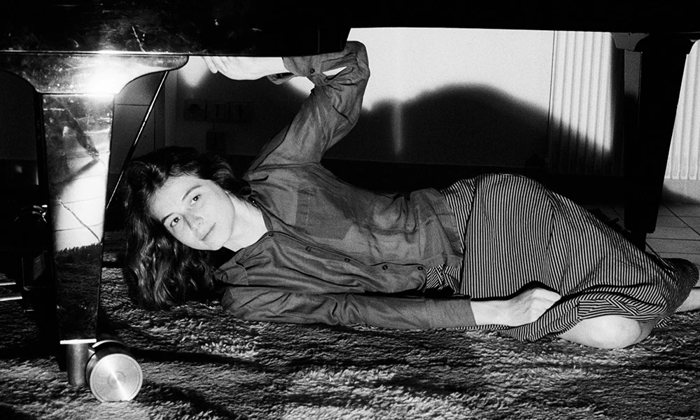 Black-and-white portrait of Eliana Glass beside a piano