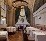 Tables, curved booths and large windows inside Belcanto