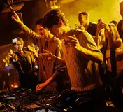 The DJ booth and yellow-lit crowd at K Urban Beach