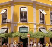 The yellow corner building and terrace of Café Janis