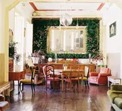 Tables, chairs and tall windows inside Casa Independente