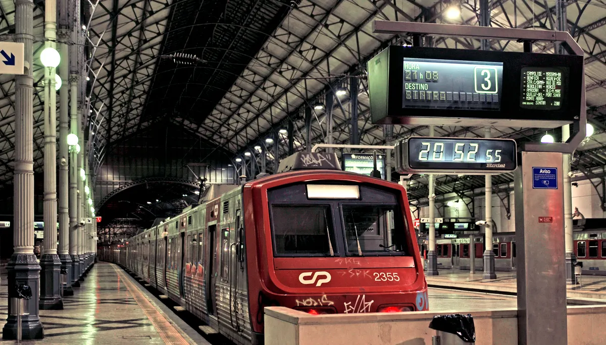 A CP suburban train beside a platform at Rossio station in Lisbon