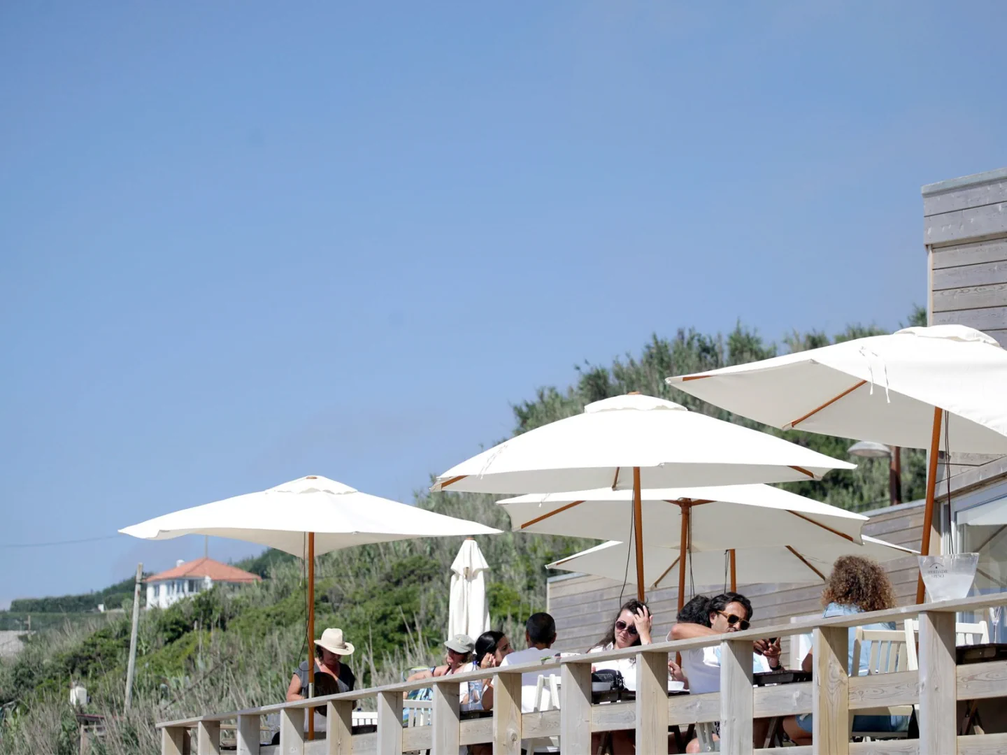 Outdoor tables and white parasols at Bar do Fundo on Praia Grande