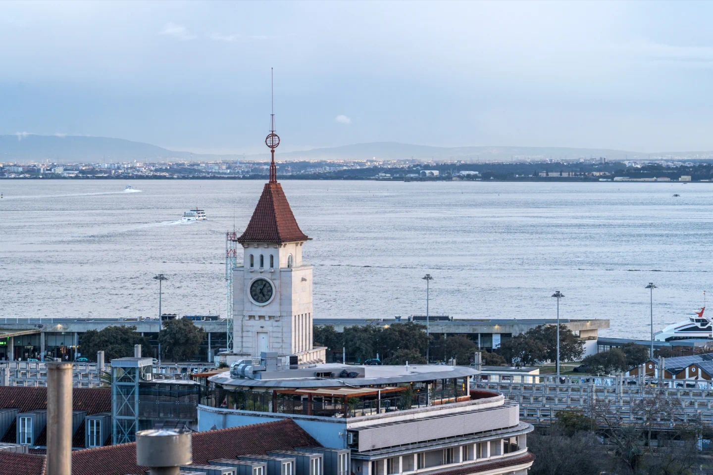 The clock tower of the CTT building and Lisbon waterfront seen from Miradouro de Santa Catarina, overlooking the Tagus.