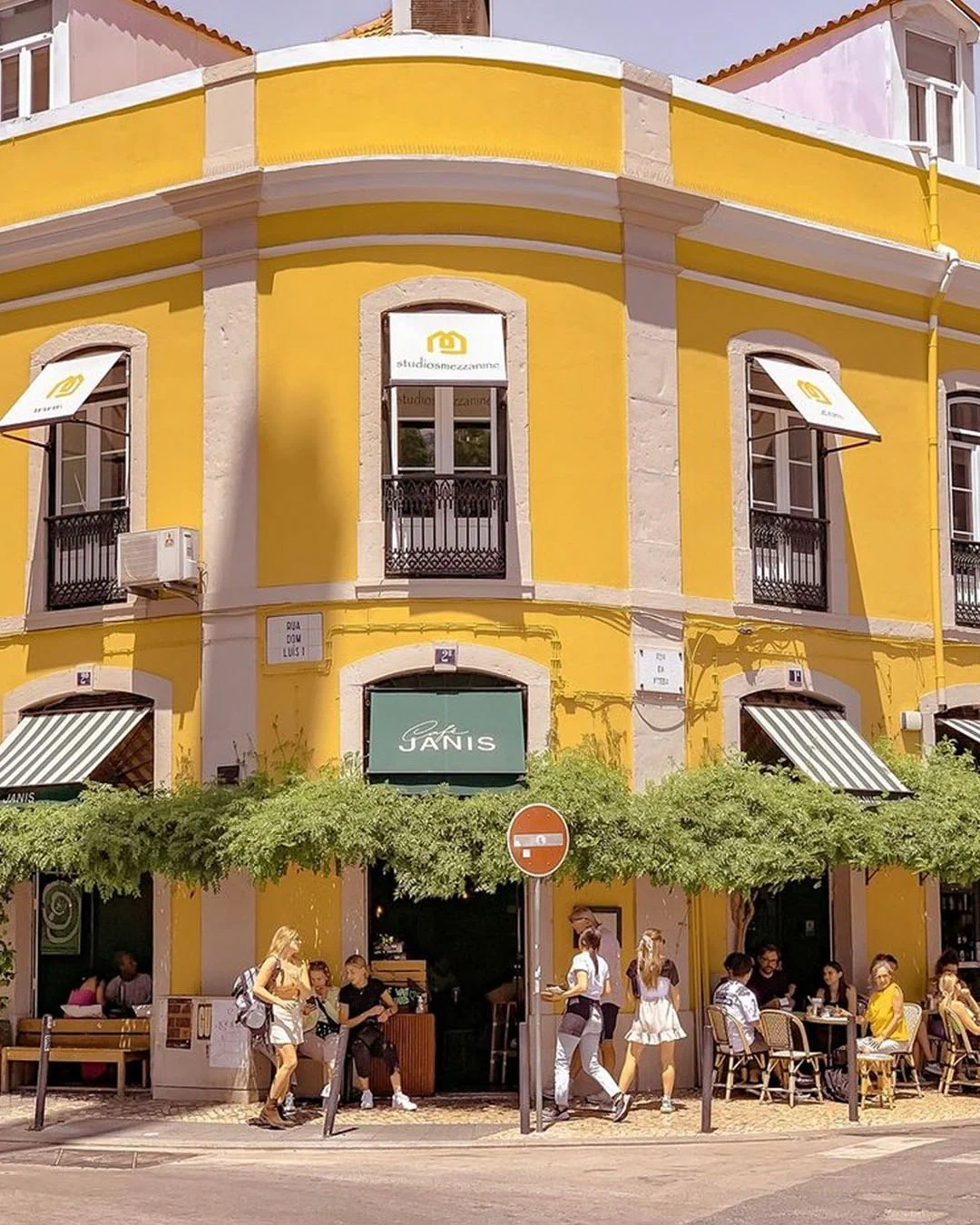 The yellow corner building and terrace of Café Janis