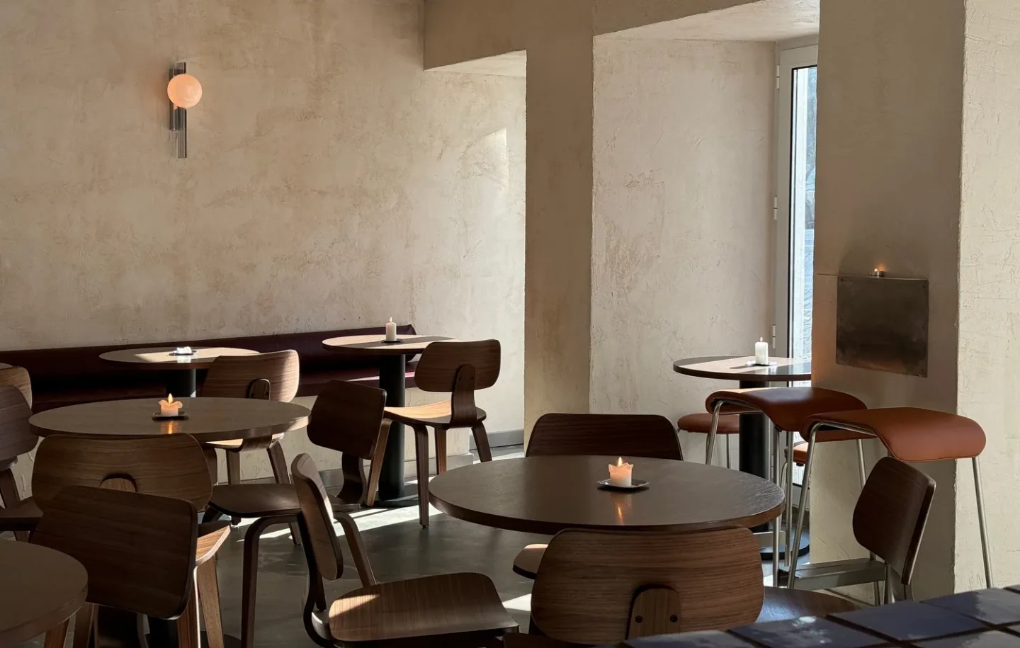 Wooden chairs and candlelit tables inside Nata Wine Bar