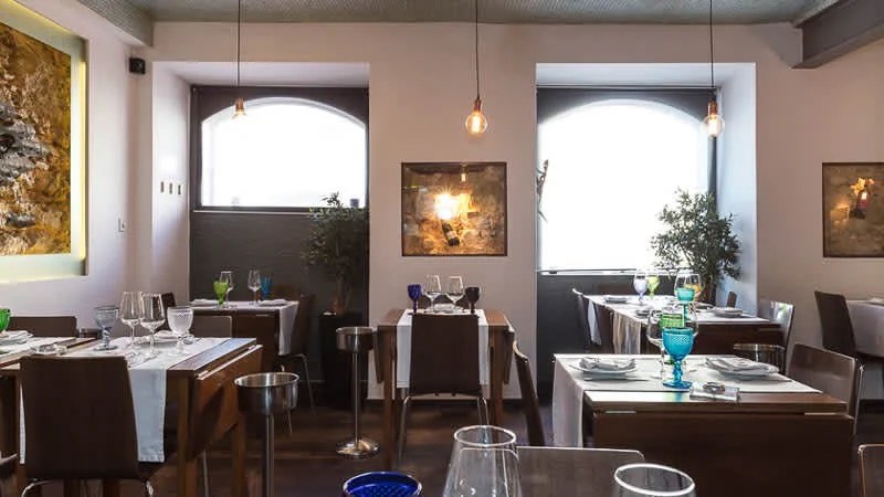 Tables, pendant lights and artwork inside Frade dos Mares